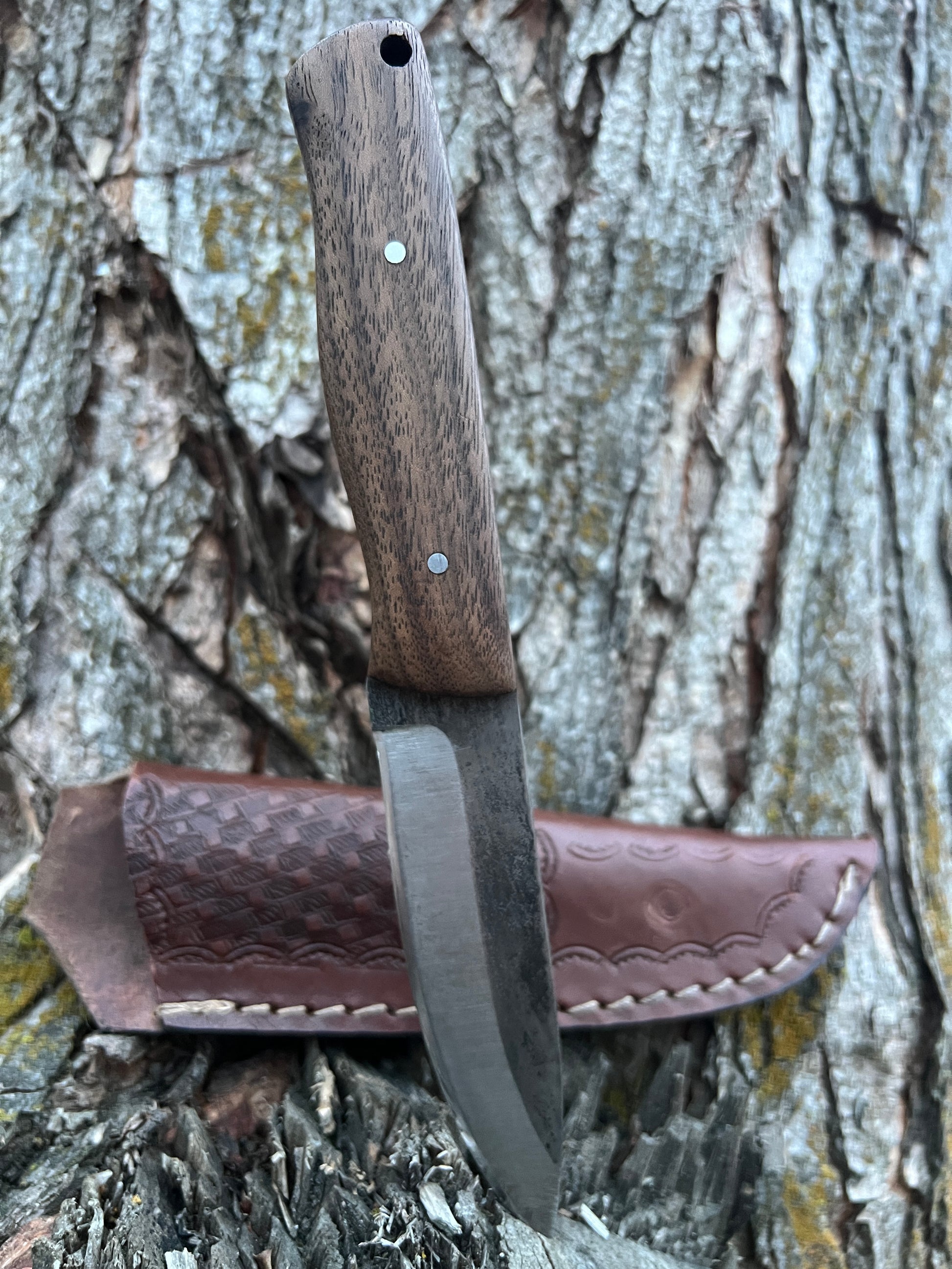 Bushcraft knife with leather sheath in outdoors